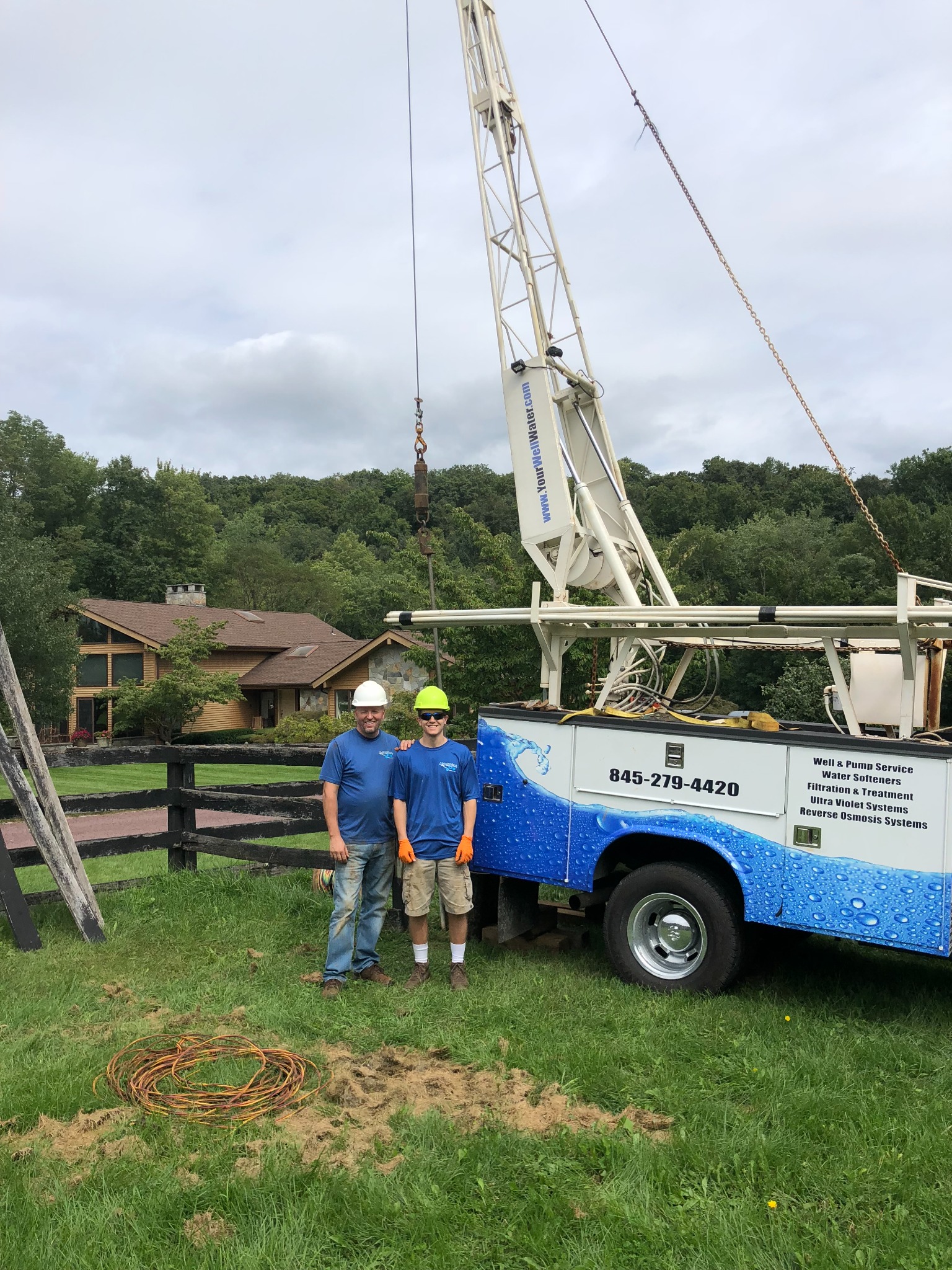 Well Pump Pro crew working beside a modern hoist truck